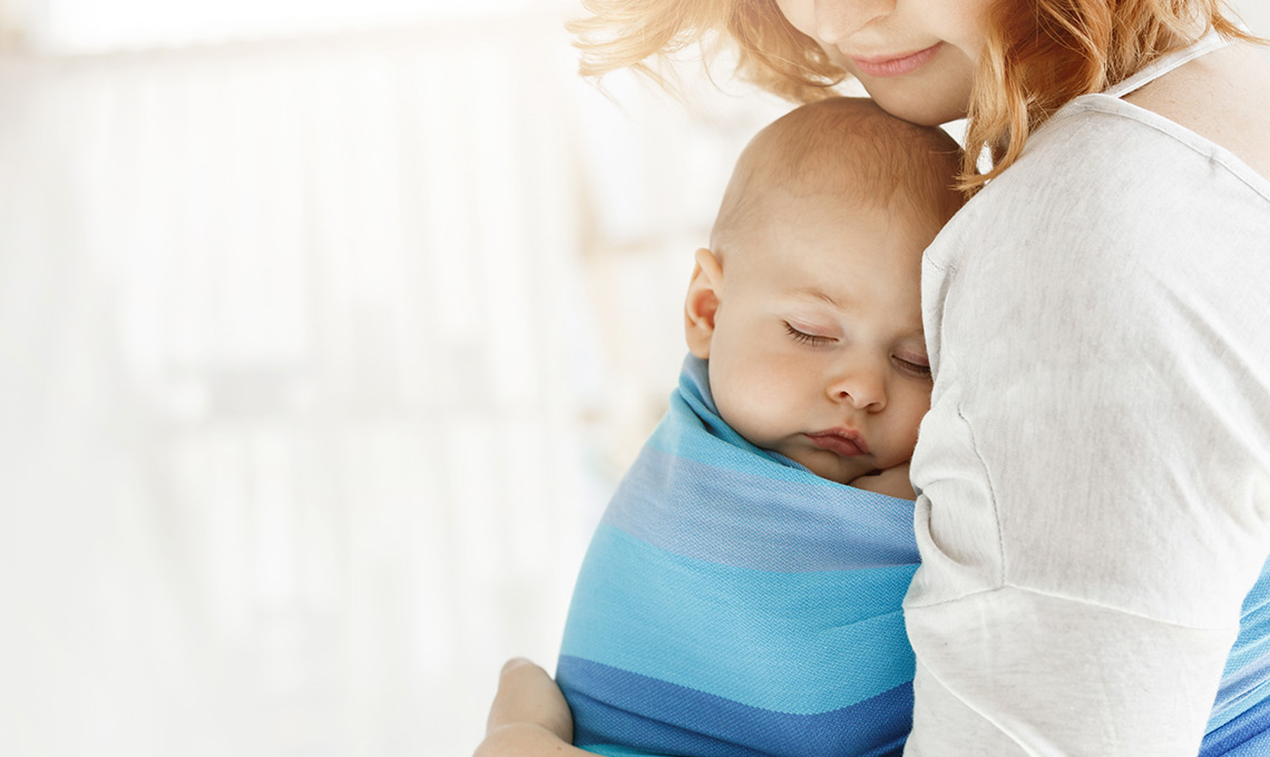 Mutter mit schlafenden Baby im Tragetuch